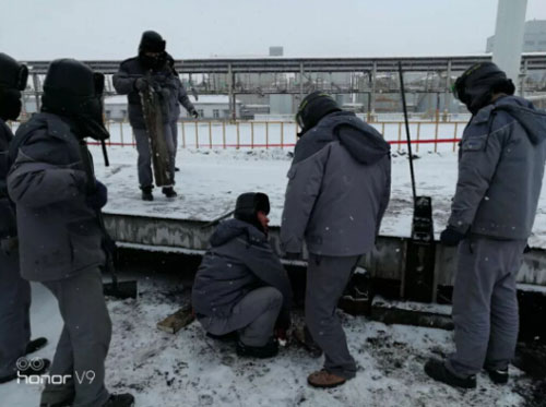 圖為車間師傅在雪地調(diào)試地磅現(xiàn)場